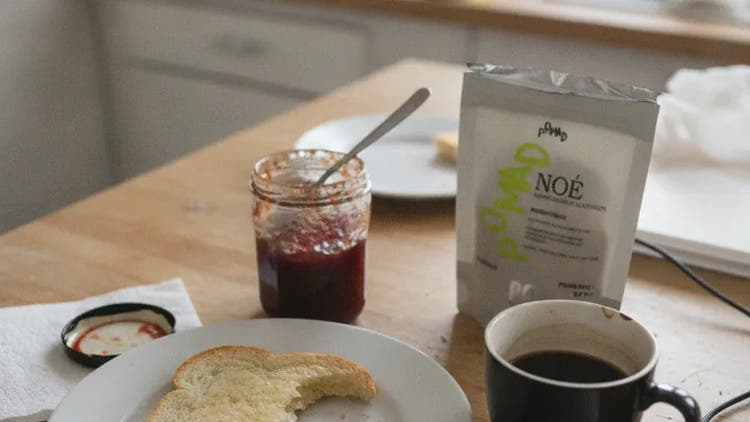 Un petit déjeuner pris à la va-vite, le sachet de Noé et une gélule posés sur la table