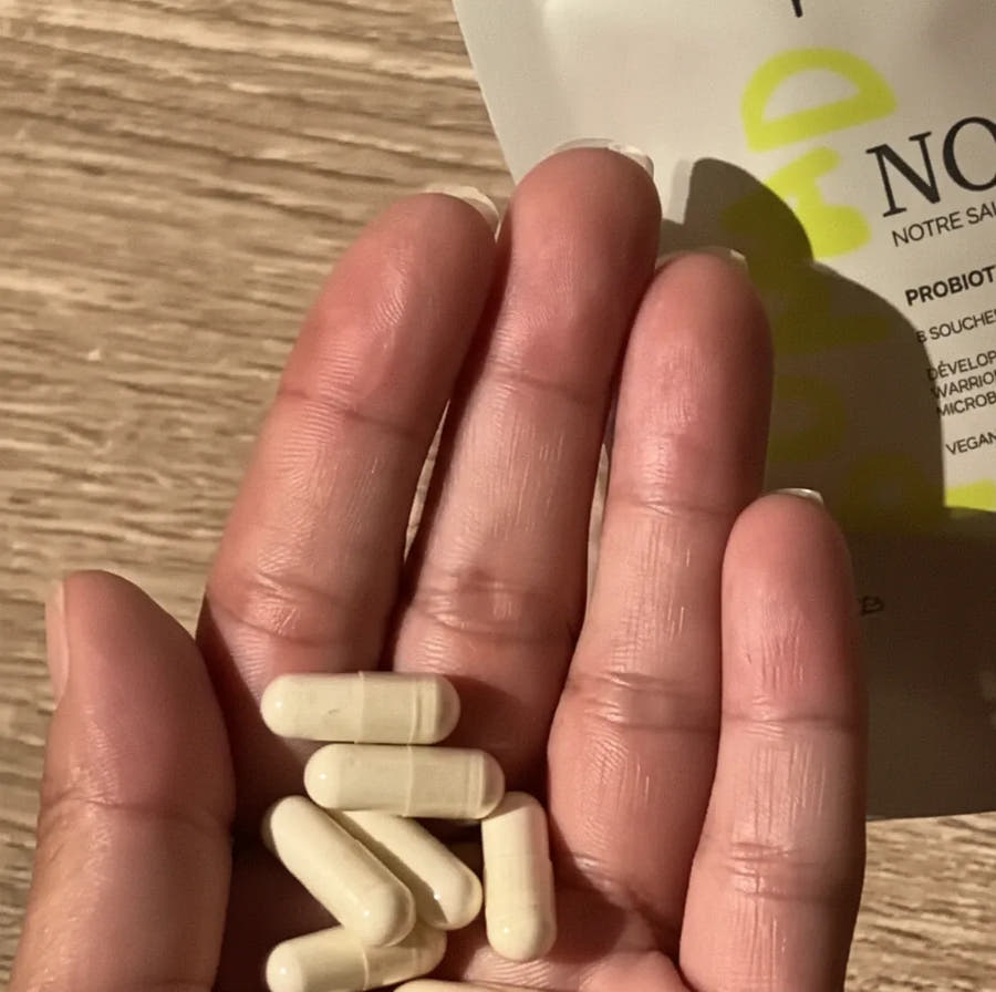 Les gélules Noé versées au creux de la main, sur une table, au moment de la prise du matin
